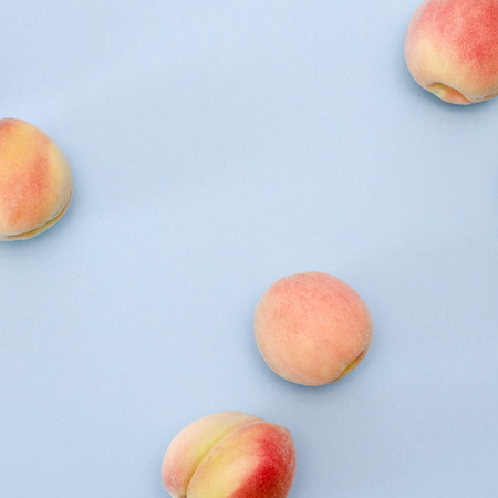 Whole ripe beautiful peaches on blue background