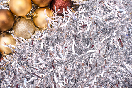 Beautiful Christmas toys of gold, brown colors on the background of silver tinselの写真素材