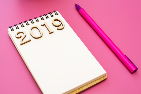 Notebook with inscription 2019 and pen on purple backgroundの写真素材