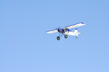 A small white plane flying in the blue sky