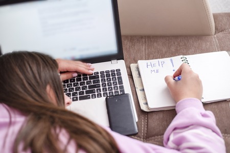 The woman was tired of working on a laptop on the couch and writing on a notebook Help me