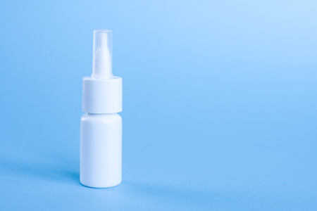 Clean white bottle with no labels for spray on blue backgroundの写真素材