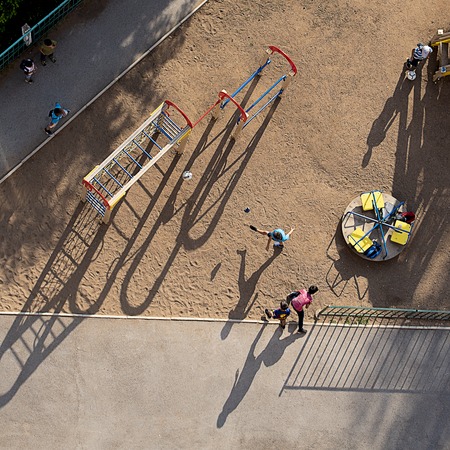 Guys chase the ball in the yard on the Playground on a Sunny clear summer day. The view from the top.の写真素材