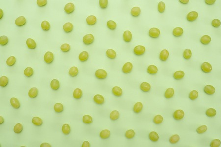 Beautiful summer delicious juicy green grapes on a green background. Top viewの写真素材