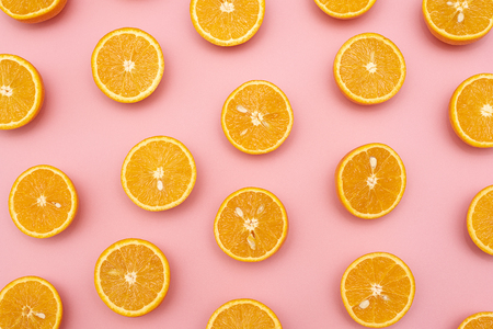 Orange juicy oranges split in half on pink backgroundの写真素材
