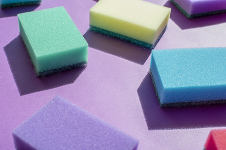 Multi-colored rectangular sponges for washing dishes on a purple backgroundの写真素材