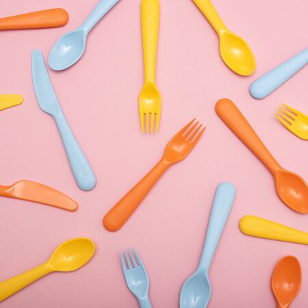 Colorful tableware : spoon, knife, fork on pink background. Top view. Flat lay.の写真素材