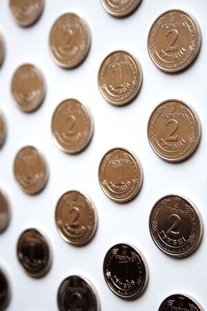 Silver coins pattern of one and two Ukrainian hryvnias on white background