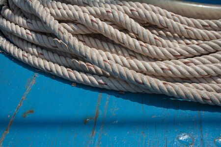 Ship rope hank detail on turquoise painted wooden background