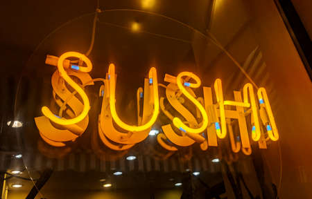 Sushi yellow neon lighting sign on restaurant window display