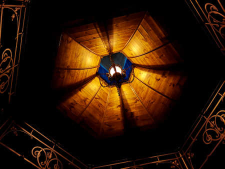 Night park rotunda round ceiling detail illuminated with glowing vintage lamp at topの写真素材