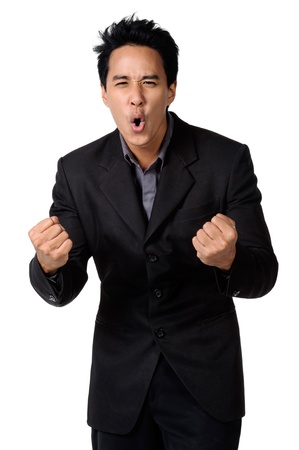 A cheerful young businessman in a black suit with clenched fistの写真素材