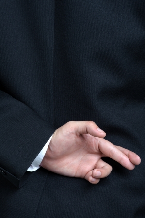 Business man lying fake hand Fingers Crossedの写真素材