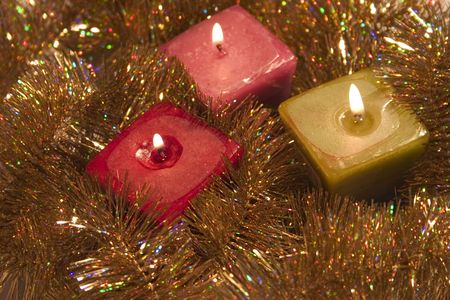 Burning candles surrounded by gold Christmas garlandの写真素材