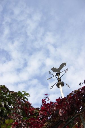 Nice metal weathervane against a cloudy but blue skyの写真素材