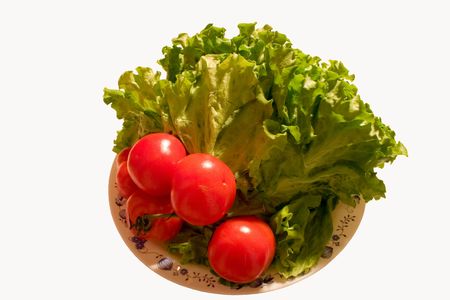 Fresh lettuce and tomato in dish isolated over white.の写真素材
