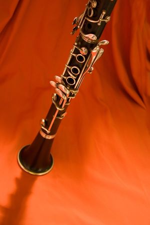 Clarinet standing upright on bright orange background signifying heat.の写真素材