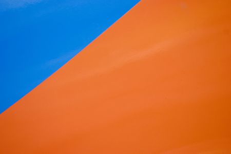 Side of an old van painted bright orange and blue made a nice abstract.の写真素材