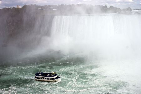 View of Niagra Falls with tour boat filled with people.の写真素材