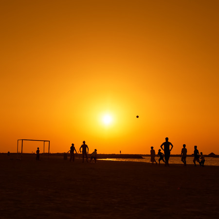 Amateurs playing football at Jumeira beach in Dubai during sunset.の写真素材