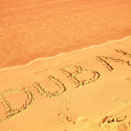 Dubai written on sand on beachの写真素材