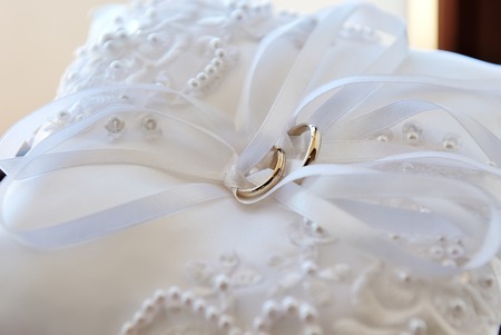 Wedding rings on a white pillowの写真素材