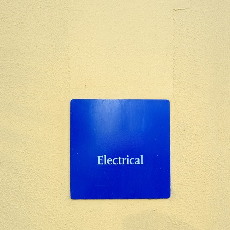 Blue electrical Sign on the yellow wall.の写真素材