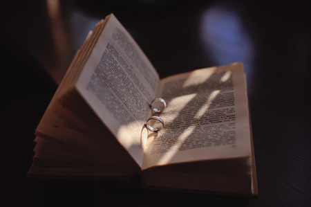Wedding golden rings between pages of a russian bookの写真素材