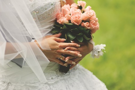 Wedding couple together. Bride holding bouquet of pink roses.の写真素材