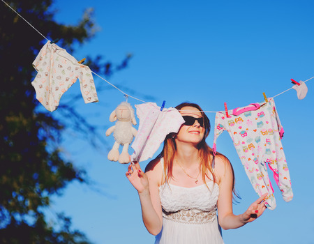 cute pregnant woman in decorated garden. Motherhood.の写真素材