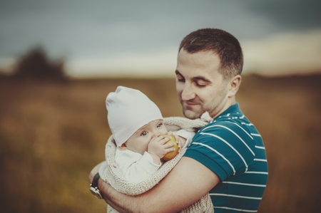 Happy father and lovely daughter in sunset light at countryside.の写真素材