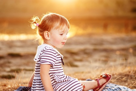 Lovely girl kid sitting wih big watermelon at countryside, having fun.の写真素材