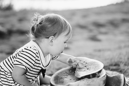 Cute girl kid sitting wih big watermelon at countryside, having fun.の写真素材