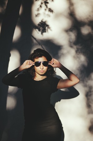 Sexy brunette in sunglasses outside posing. Portrait of a young woman.の写真素材