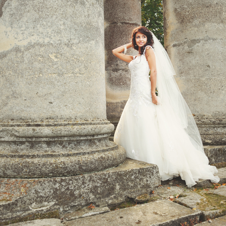 Young caucasian bride next to old church.