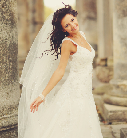 Beautiful bride posing on the steps of an old church in west Ukraineの写真素材