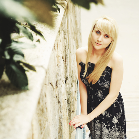 Portrait of a blond woman in black dress outdoor. Summertime.の写真素材