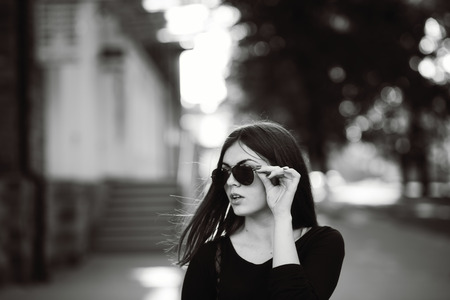 street fashion portrait of a young dark hair girl in black and whiteの写真素材