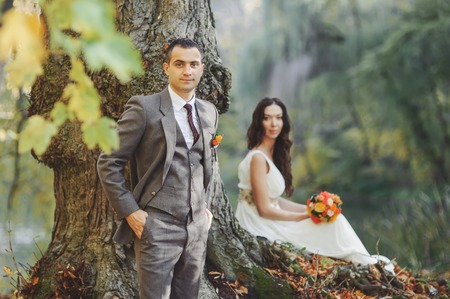 Wedding couple in forest next to big old tree.  Groom and bride together.の写真素材