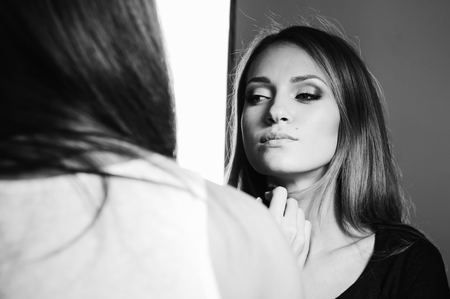Young woman having make up aplying by artist in studio.の写真素材