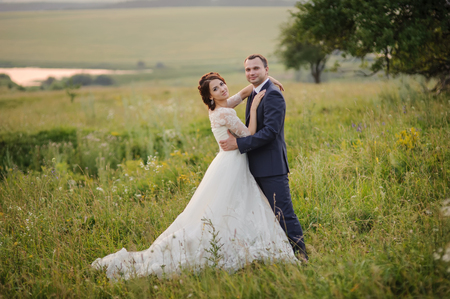 Wedding couple at countryside during sunset. Groom and bride together.の写真素材