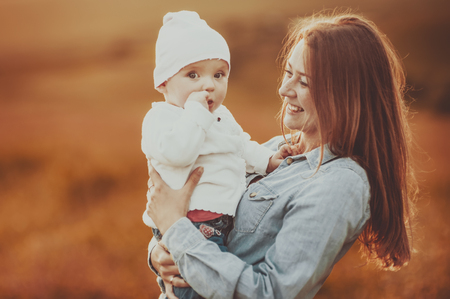 Happy young mom with lovely daughter at countryside.の写真素材