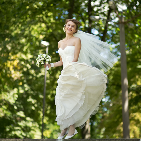 Young happy bride jumping. Summertime picture.の写真素材