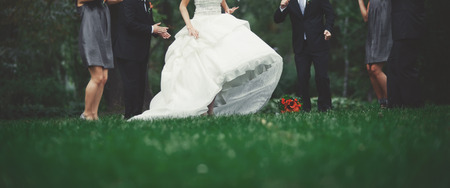 Happy bridal couple with guests  in garden. Summer wedding picture.の写真素材