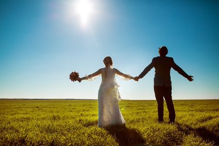 Happy wedding  couple in field. Young groom and bride.の写真素材