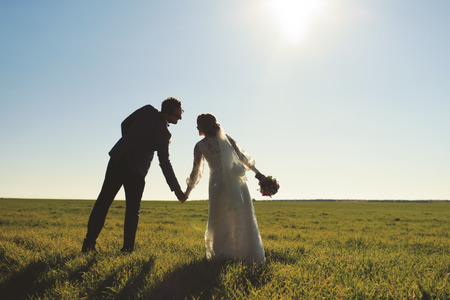 Young newly wed couple at field. Groom and bride together.の写真素材
