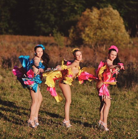 three dancing girls in autumn