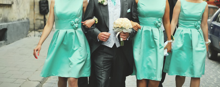 Wedding picture.  Groom and bridesmaid walking street.の写真素材