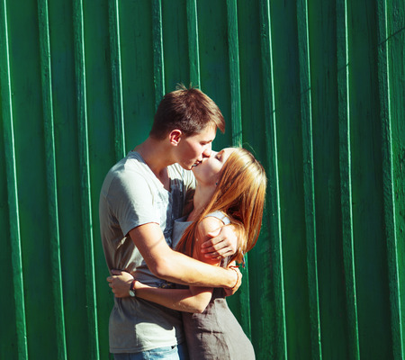 Happy teen couple kissing outside.の写真素材