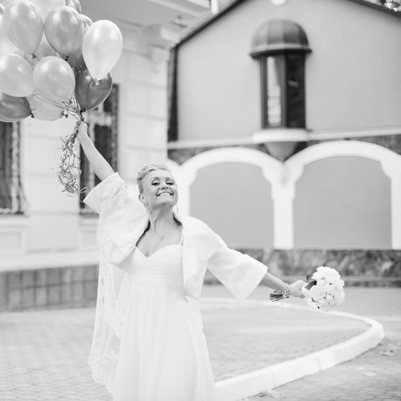 Gorgeous caucasian bride in beautiful dress with balloons.の写真素材